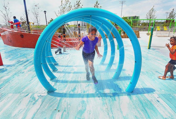 Girl running through tunnel of water spray