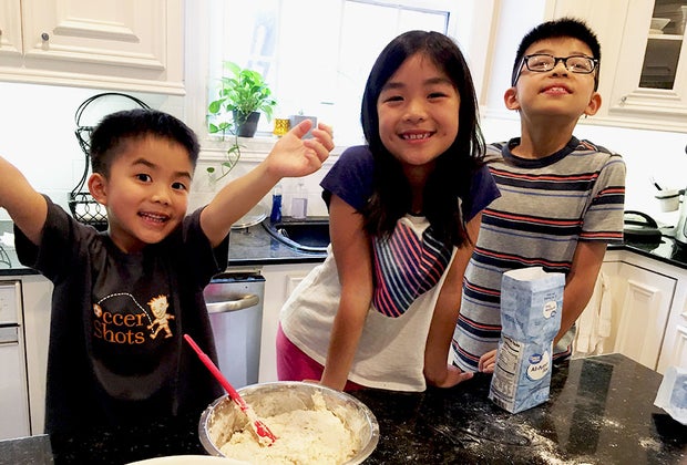 kids at at a counter cooking in the kitchen