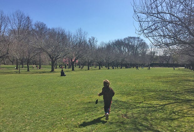 boy running in field brooklyn botanic garden