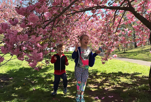 Two smiling kids playing among the cherry trees cherry blossoms at Branch Brook Park