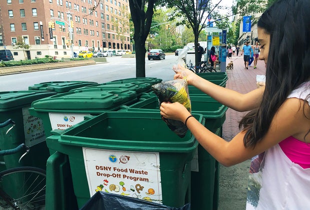 girl composting in a city compost bin
