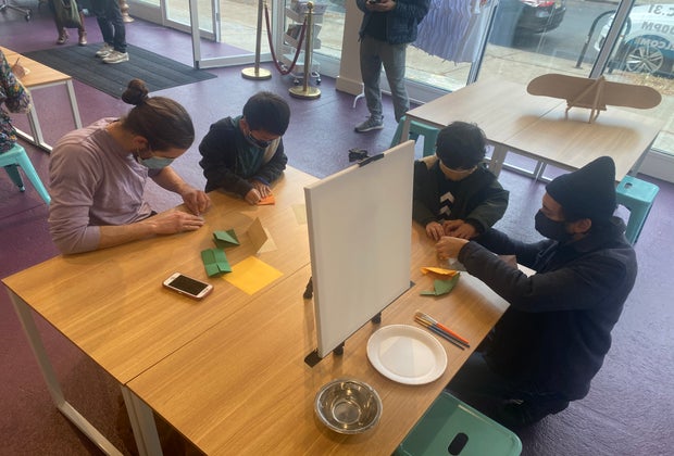 Family creates origami at Playday Cobble Hill