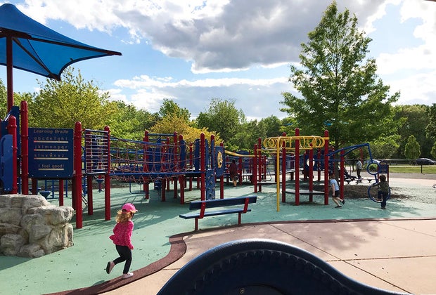 Girl running through Jake's Place playground