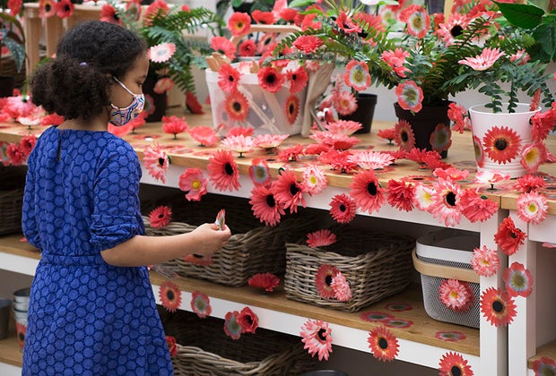 girl placing a flower in Kusama piece Flower Obsession at NYBG