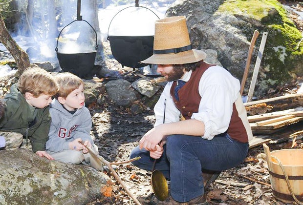 Image of actors in period costume making maple syrup in Sturbridge.