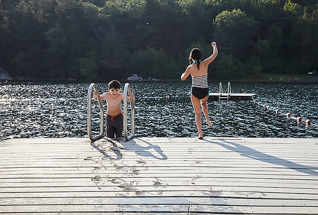 Family-friendly hotels in the Hudson Valley: Kids jumping off a dock into a lake at Mohonk Mountain House