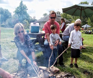 Families cook cornbread over the fire at Cider Saturday. Photo courtesy of New Canaan Nature Center