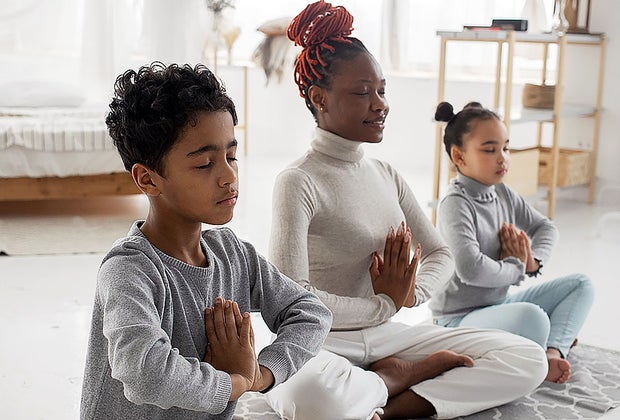 Mom doing yoga with kids as an example of gentle parenting.