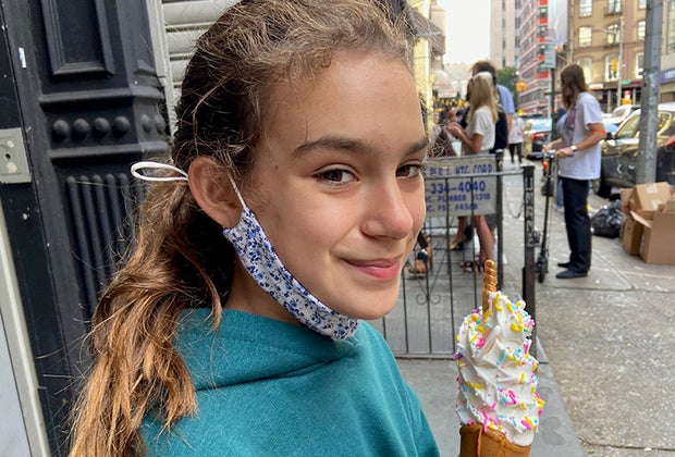 Taiyaki NYC. girl eating a unicorn ice cream in a fish shaped cone