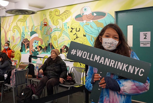 Girl standing in front of mural at Wollman Rink in Central Park.